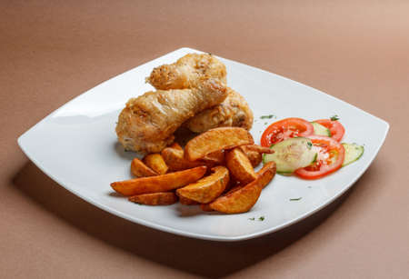 Grilled chicken drumsticks with potatoの写真素材