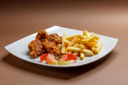 Breaded chicken wings  with french friesの写真素材