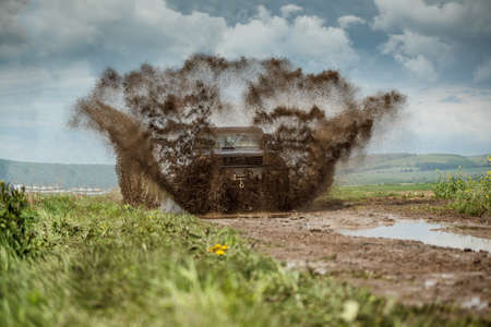 Off road car in muddy road splashing mudの写真素材