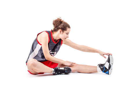Basketball woman stretching leg on white background の写真素材