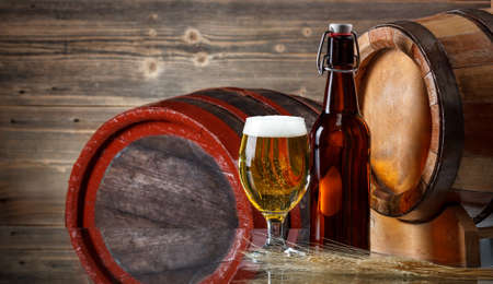 Beer barrel with beer glasses and bottle on a wooden tableの写真素材