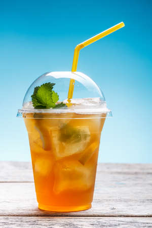 Fresh ice tea in plastic glass with strawの写真素材