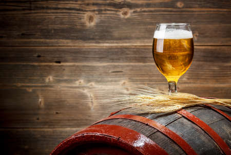 Glass of beer on old barrel 