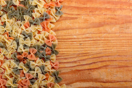 Uncooked farfalle pasta on rustic wooden backgroundの写真素材