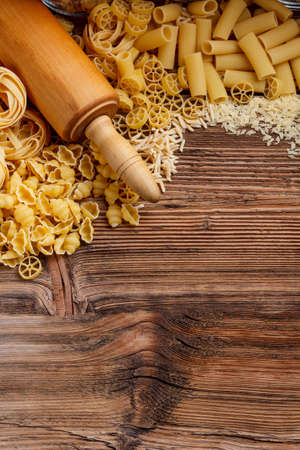 Raw pasta on wood background textureの写真素材