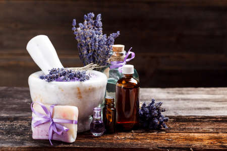Still life with lavender salt, bottles, soap and dry lavender flower, on wooden tableの写真素材