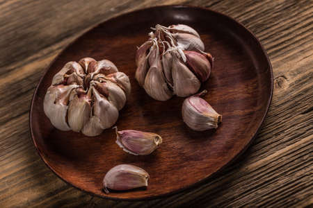 Bulb of garlic in wooden plate