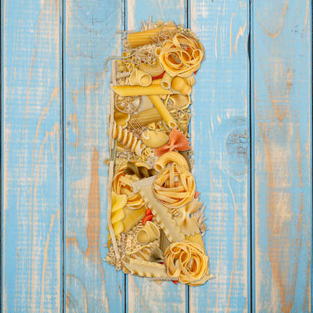 Letter I made from pasta on a blue wooden  backgroundの写真素材