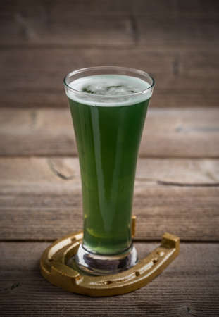 Glass of green beer and horseshoe for St Patricks dayの写真素材