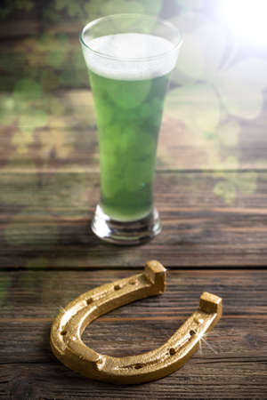 Glass of green beer and horseshoe for St Patricks dayの写真素材