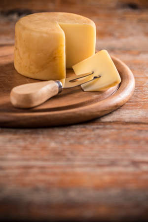 Cheese with fork on wooden table