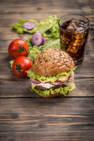 Glass of cola with ice and hamburgerの写真素材