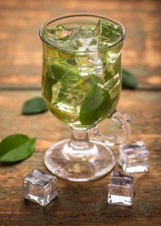Cup of ice tea with green tea leafの写真素材
