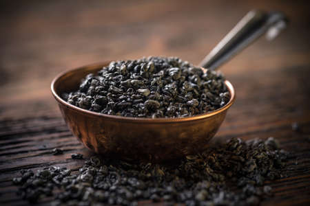 Leaves of green tea in copper bowlの写真素材