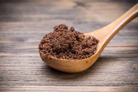 Spoon of muscovado sugar on wooden boardの写真素材