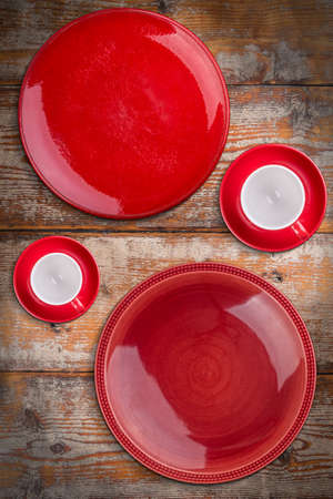 Red plates and coffee cups on wooden backgroundの写真素材