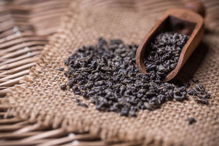 Green tea leaves in wood scoopの写真素材