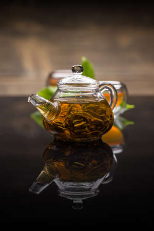 Teapot with tea on the reflective surfaceの写真素材