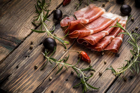 Slices of prosciutto on a vintage wooden tableの写真素材