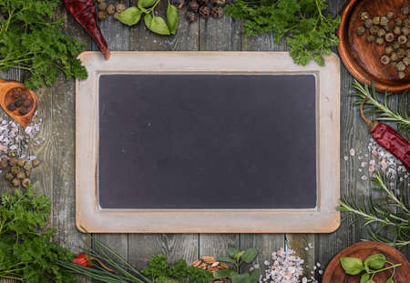 Green herbs as frame around a grungy blackboard for menuの写真素材