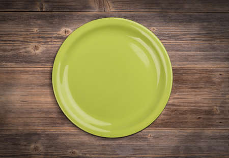Green plate on vintage wooden boardの写真素材
