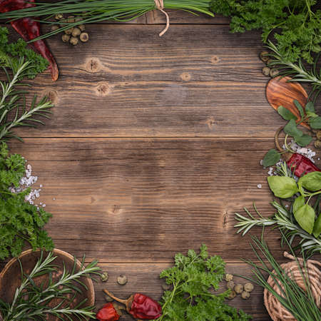 Green fresh herbs mix on wooden background , top viewの写真素材