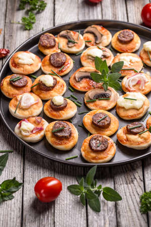 Kitchen pan with different kinds of small pizzasの写真素材