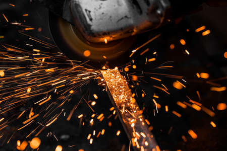 Grinding machine in action with bright sparks. Construction and manufacturing theme.の写真素材