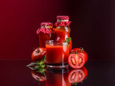 Homemade tomato juice composition on red backgroundの写真素材