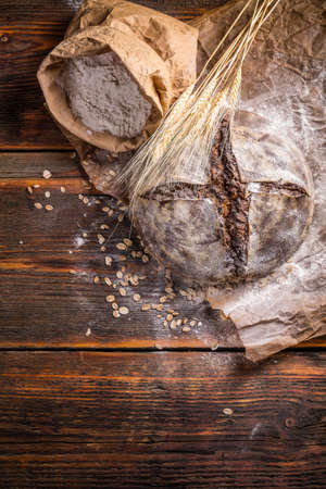 A rustic loaf of sourdough bread on wooden backgroundの写真素材