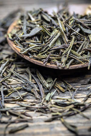 Leaves of green tea in wooden spoonの写真素材