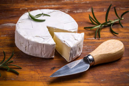 Camembert cheese with knife on wooden tableの写真素材