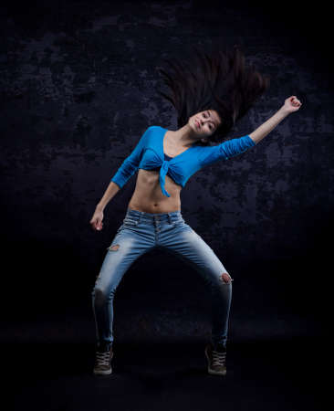 Young beautiful dancer posing on a grungy backgroundの写真素材