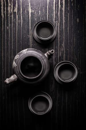 Top view of asian teapot and three bowls of tea
