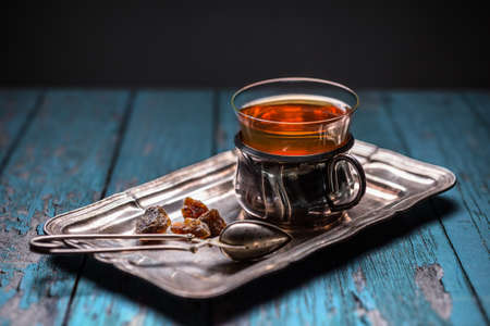 Tea in a glass with a cup holder on metal trayの写真素材
