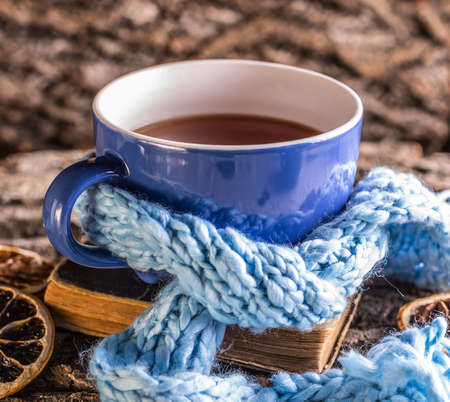 Cup of tea wrapped in blue scarfの写真素材