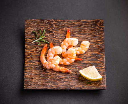 Shrimps or prawns on bamboo plate with lemonの写真素材