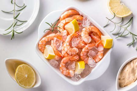 Fresh raw prawns on ice with lemonの写真素材