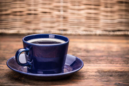 Cup of coffee with saucer served on wooden tableの写真素材