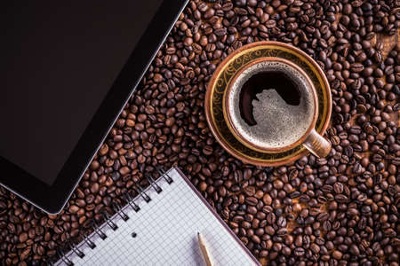 Cup of coffee with tablet pc and notebookの写真素材