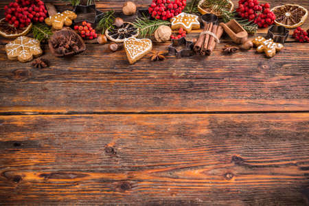Gingerbread, dry orange and fir branches on wooden board