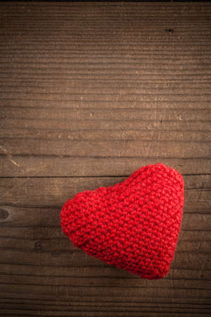 Knitted heart on rustic wooden backgroundの写真素材