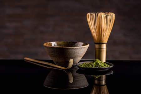 Organic green matcha tea in a bowl and matcha utelsilsの写真素材