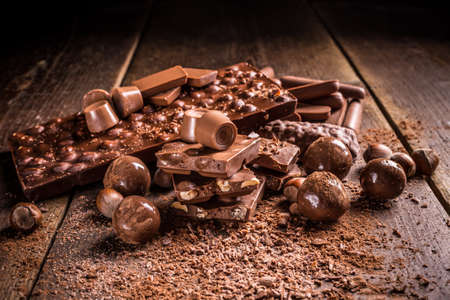 Tasty sweets chocolates and pralines on rustic wooden board
