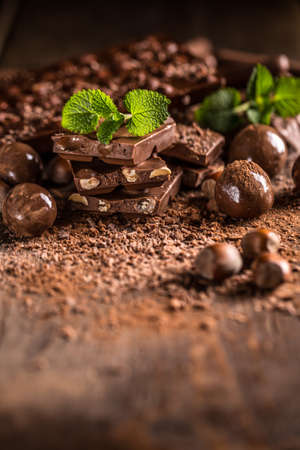 Pile of assorted chocolate bars on wooden background