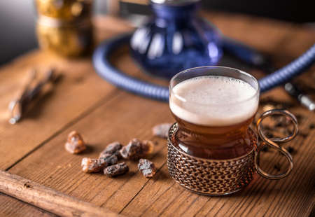 Cup of tea with glass-holder on wooden table