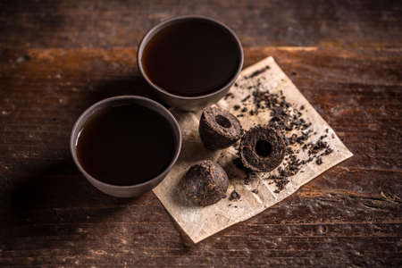Still life with pressed pu-erh tea and two small cupsの写真素材