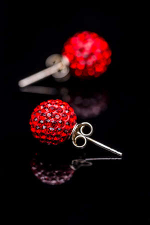Earrings with red stones on black reflection backgroundの写真素材