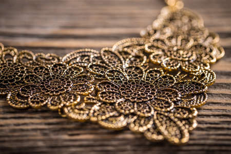Metal feminine necklace on rustic wooden backgroundの写真素材