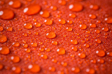 Red waterproof coating background with water dropsの写真素材